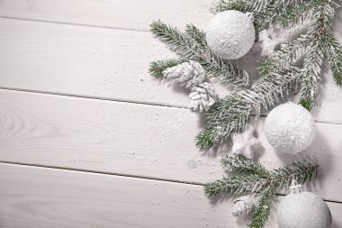 Tahta arka planda Noel ağacı dalları olan bir Noel kartı.