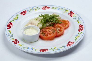 Beyaz tabakta domatesli kızarmış balık, yakın görüş. 