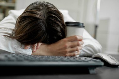 Yorgun iş kadını ofisten sonra masada yatıyor..