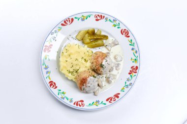 Beyaz tabakta patates püresi ve soslu köfteler, yakın görüş. 