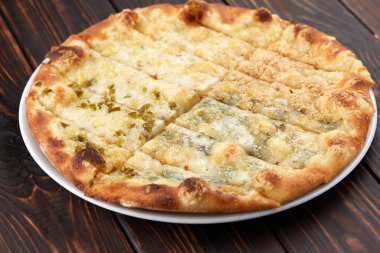 Tahta arka planda sıcak lezzetli pizza, yakın görüş. 