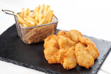 Patates kızartması ve tavuklu nugget. Kesme tahtası, yakın görüş. 