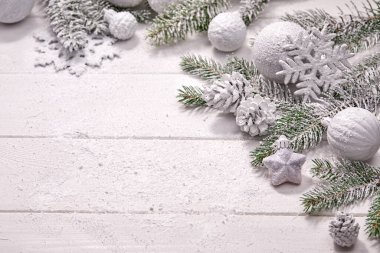 Beyaz topları ve tahta arka planda köknar dalı olan Noel kartı.