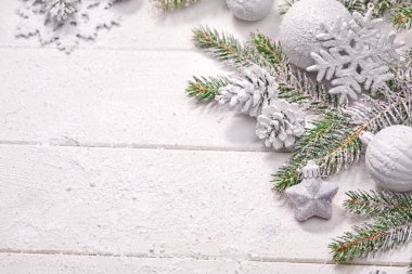 Beyaz topları ve tahta arka planda köknar dalı olan Noel kartı.