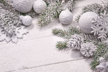 Beyaz topları ve tahta arka planda köknar dalı olan Noel kartı.