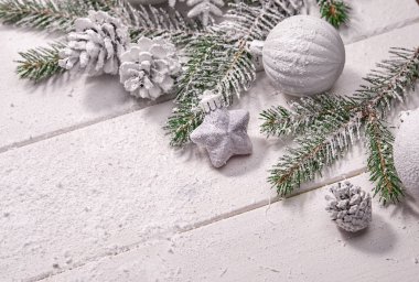 Beyaz topları ve tahta arka planda köknar dalı olan Noel kartı.