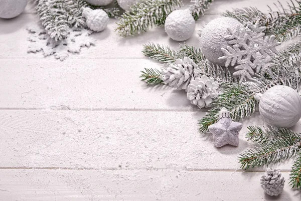 Beyaz topları ve tahta arka planda köknar dalı olan Noel kartı.