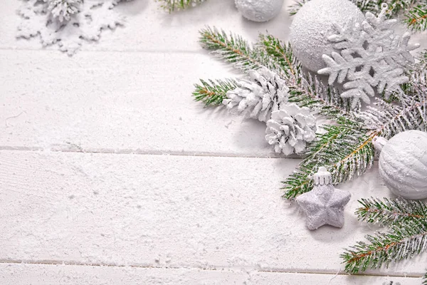 Beyaz topları ve tahta arka planda köknar dalı olan Noel kartı.