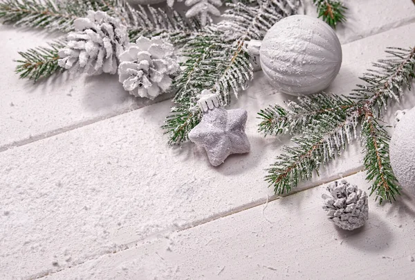 Beyaz topları ve tahta arka planda köknar dalı olan Noel kartı.