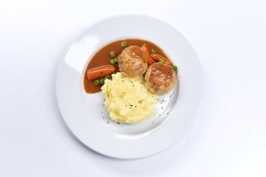 Beyaz tabakta patates püresi ve sebzeli köfte, yakın görüş. 