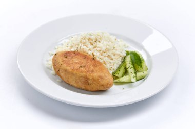 Pirinçli pirzola ve beyaz tabakta salatalık, yakın görüş.