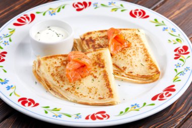 Somonlu gözleme ve beyaz tabakta ekşi krema, yakın görüş. 