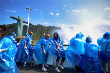Niagara Falls, Amerika Birleşik Devletleri - 29 Ağustos 2018: Mutlu grup turist Niagara Falls izlerken tekne tur mavi yağmurluklar