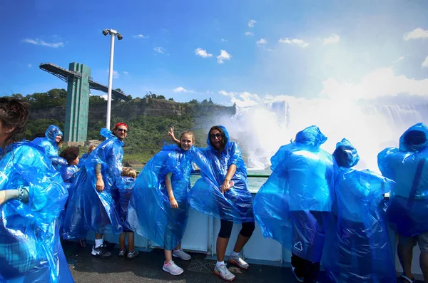 ナイアガラの滝 アメリカ合衆国 2018 幸せなグループ観光客がナイアガラの滝を見てボート ツアーで青いレインコート — ストック写真