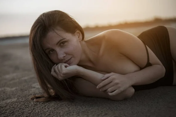 Schöne Oben-ohne-Frau liegt im Sand. — Stockfoto