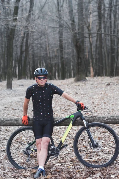 Männlicher Sportler Mountainbiker mit Fahrrad auf einem Waldweg. im Waldnebel — Stockfoto