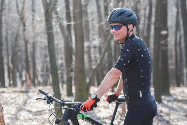 Atleta masculino montanhista com bicicleta ao longo de uma trilha florestal. na névoa florestal — Fotografia de Stock