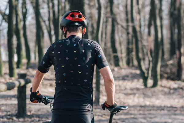 Atleta masculino montanhista com bicicleta ao longo de uma trilha florestal. na névoa florestal — Fotografia de Stock