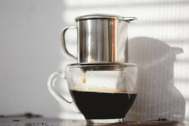 Gün batımında kahve demlenir. Geleneksel Vietnam phin filtreli kahve minimalist tarzı.