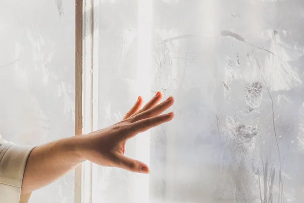 Hermosa chica joven dibuja en la ventana congelada —  Fotos de Stock