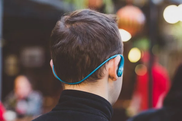 Visão traseira de um jovem com fones de ouvido — Fotografia de Stock