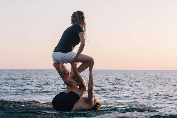 夫妻二人在海滩上做瑜伽练习 — 图库照片