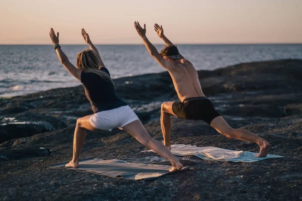 Fitness, sport i koncepcja stylu życia - para ćwiczy jogę na plaży — Zdjęcie stockowe