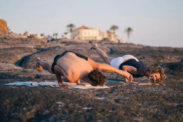 Fitness, sport és életmód koncepció - pár, akik jóga gyakorlatokat csinálnak a strandon — Stock Fotó