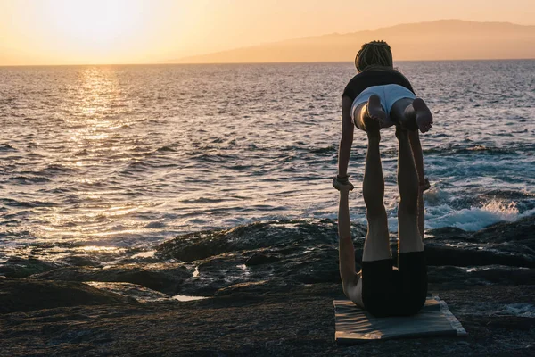 Paar macht Yoga-Übungen im Freien am Strand — Stockfoto