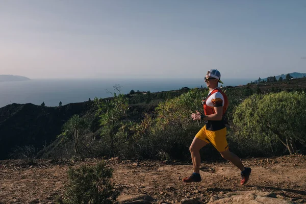 Manan corre a través del país en un camino de montaña en la isla de Canarias. Vista al mar Fotos De Stock Sin Royalties Gratis