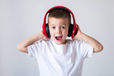 Genç çocuk kulaklıkla müzik dinliyor.