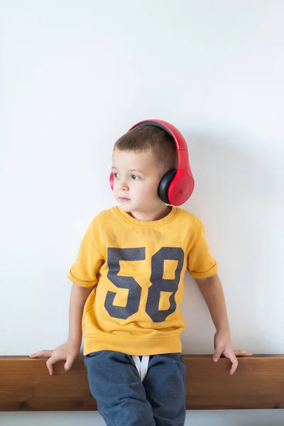 T-shirt garçon en jaune avec écouteurs isolés sur fond blanc — Photo