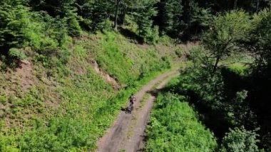 Hava görüntüsü. Bisikletçi kırsal kesimde kır yolunda bisikletini sürüyor. Seyahat ve spor. özgürlük kavramı