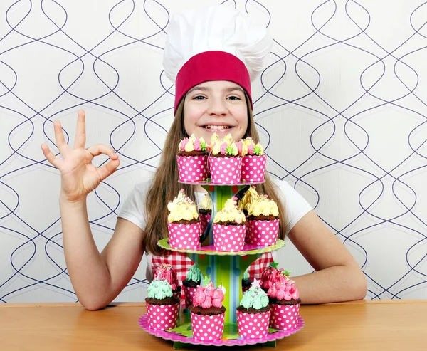 Menina Feliz Cozinheiro Com Muffins Saborosos Sinal Mão — Fotografia de Stock