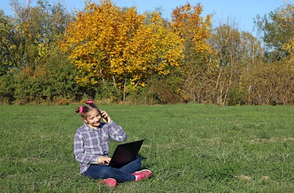 Happy Little Girl Playing Laptop Talks Smartphone — Stock Photo, Image