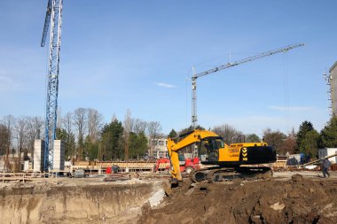 Ekskavatör işçi ve vinçler inşaat sitesinde 