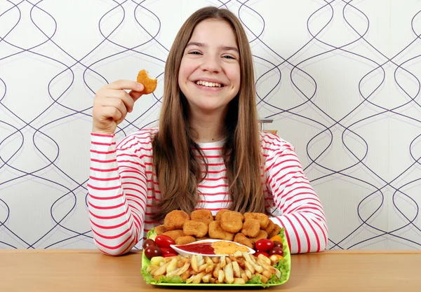 Joyeux adolescent fille avec de savoureuses pépites de poulet et frites — Photo