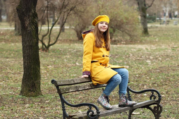 Dospívající dívka sedí na lavičce v parku — Stock fotografie