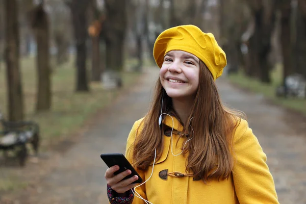 Tonårsflicka lyssnar på musik på din smartphone — Stockfoto