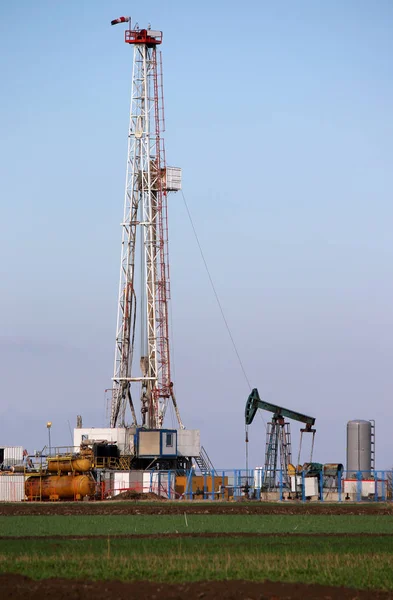 Equipamento de perfuração de petróleo e gás e macaco de bomba no campo petrolífero — Fotografia de Stock