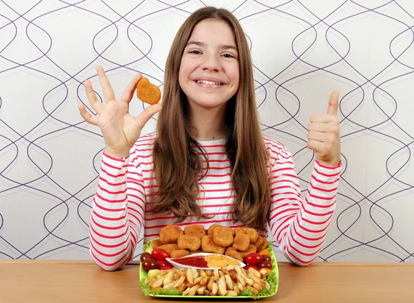Šťastný dospívající dívka s kuřecí nugety a palec nahoru — Stock fotografie