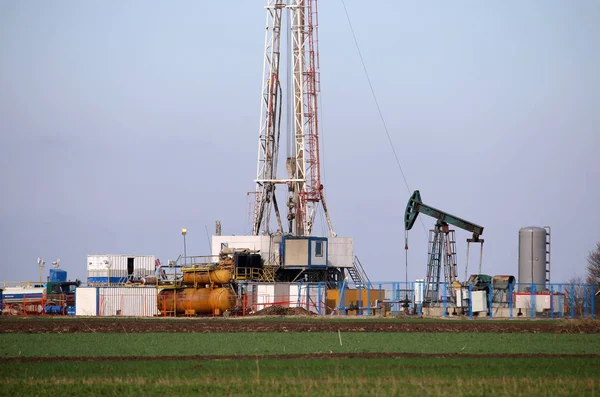 Land oil drilling rig and pump jack in oilfield — Stock Photo, Image