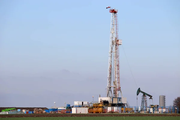 Oil and gas drilling rig and pump jack in oilfield industry — Stock Photo, Image