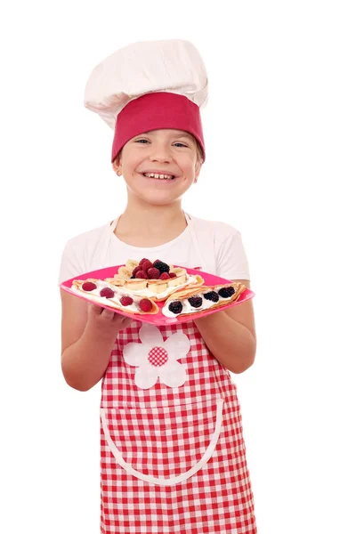Ευτυχισμένο μικρό κορίτσι μαγειρεύουν με νόστιμες γλυκές κρέπες και φρούτα — Φωτογραφία Αρχείου