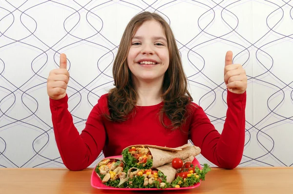 Gelukkig klein meisje met Burritos Mexicaans eten en thumbs up — Stockfoto