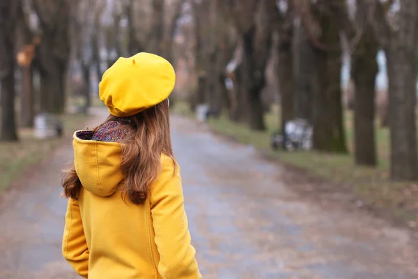 Niña con un abrigo amarillo y boina en temporada de otoño parque —  Fotos de Stock