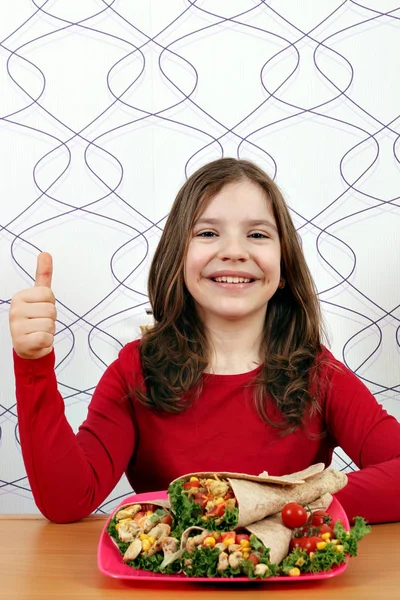 Glückliches kleines Mädchen mit Burritos und Daumen hoch — Stockfoto