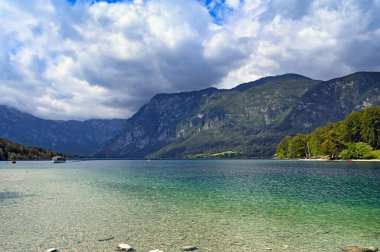 Bohinj Gölü, Slovenya. Yeşil su, orman ve dağlarla gölün manzarası 