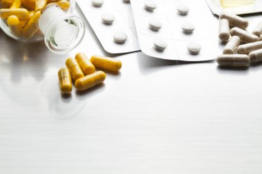 İlaçlar bir metal masa üzerinde çeşitli kapsül olarak