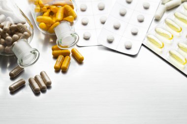 İlaçlar çeşitli kapsül ve tabletler üzerinde metal bir arka plan olarak